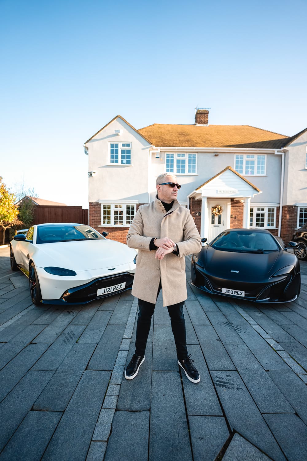 Juan Rex frente a su McLaren y su Aston Martin a la puerta de su casa